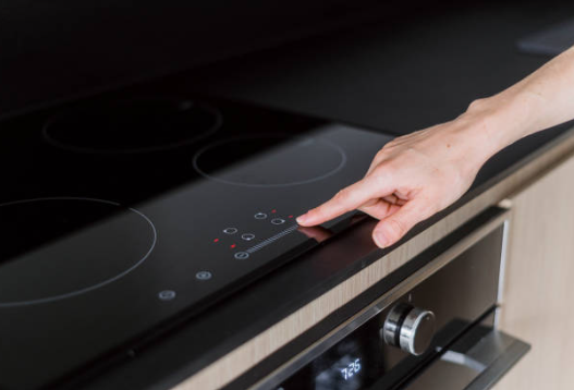 doigt qui pointe vers une plaque de cuisson à induction